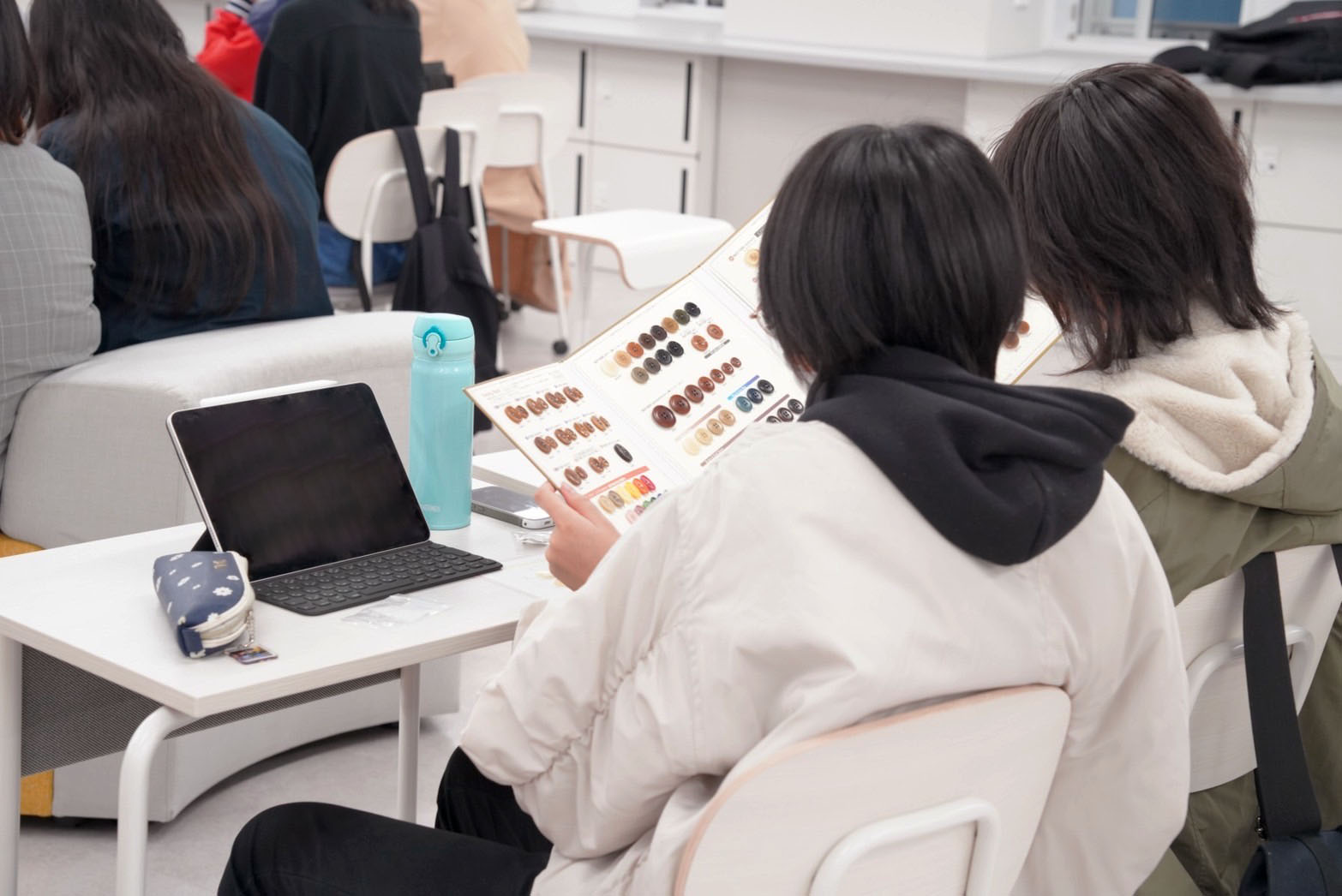 サンプル帳を見ている学生の画像